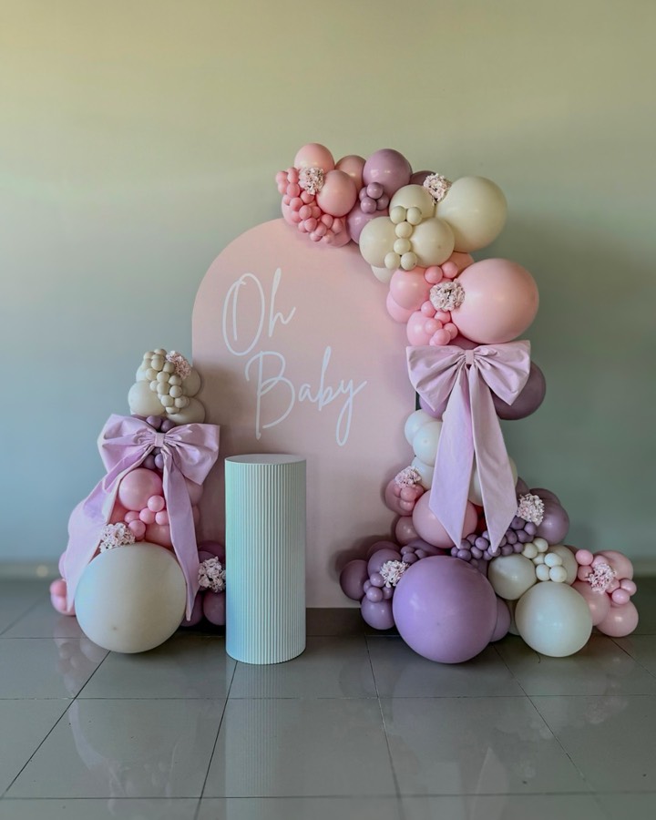 Blush “Oh Baby” backdrop with mauve balloons and lavender satin bows.